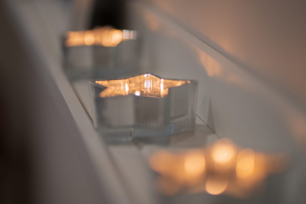 Lit candles on a shelf in the Urban Muse massage studio in Plymouth, creating a calm and welcoming atmosphere.